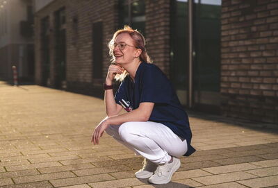 Pflegerin lachend in der Hocke